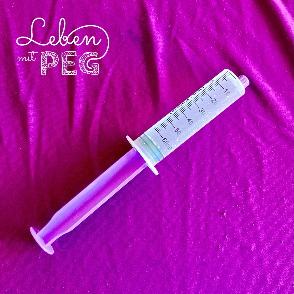 60ml EnFit Spritze mit Wasser (lila Hintergrund mit Logo "Leben mit PEG")